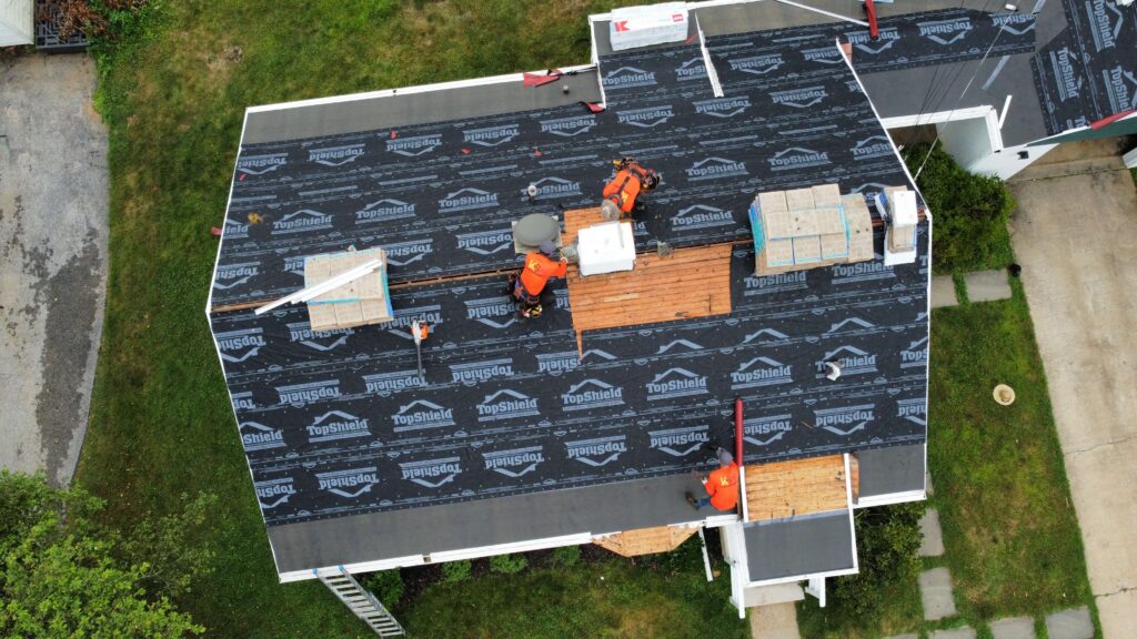 An overhead view of KSW's home improvement roofing team at work on a house.