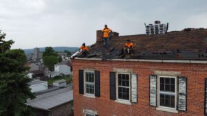 our expert roofers stands on top of a residential roofing home