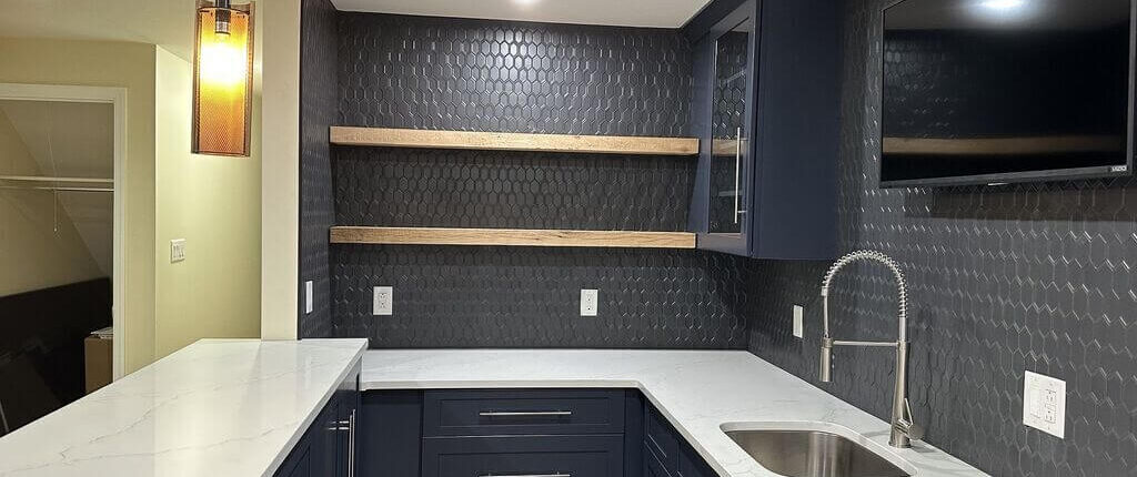 A kitchen with white counters and black cabinets