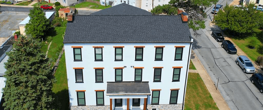 a commercial roof replacement on a white apartment building